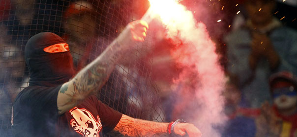 Un supporter de la Serbie lance un fumigène lors d'un match de qualification pour l'Euro 2012, contre l'Italie. © REUTERS.